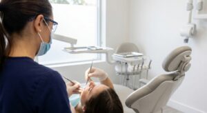 Dental hygienist performing professional teeth cleaning on patient in modern dental office in Raleigh